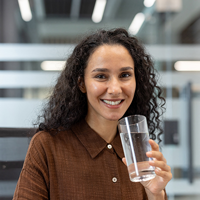 Lächelnde Frau hält Glas Wasser